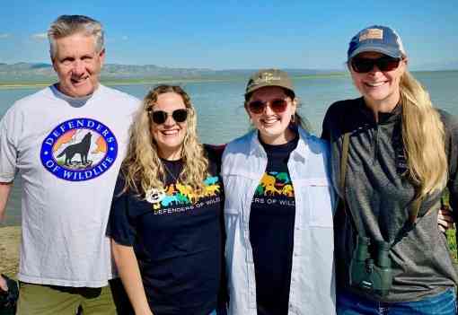 Four members of Defenders' California team (Andy Johnson, Sophia Markowaska, Ashley Overhouse and Pamela Flick) stand in front of water during their Carrizo Plain staff gathering in April 2023.
